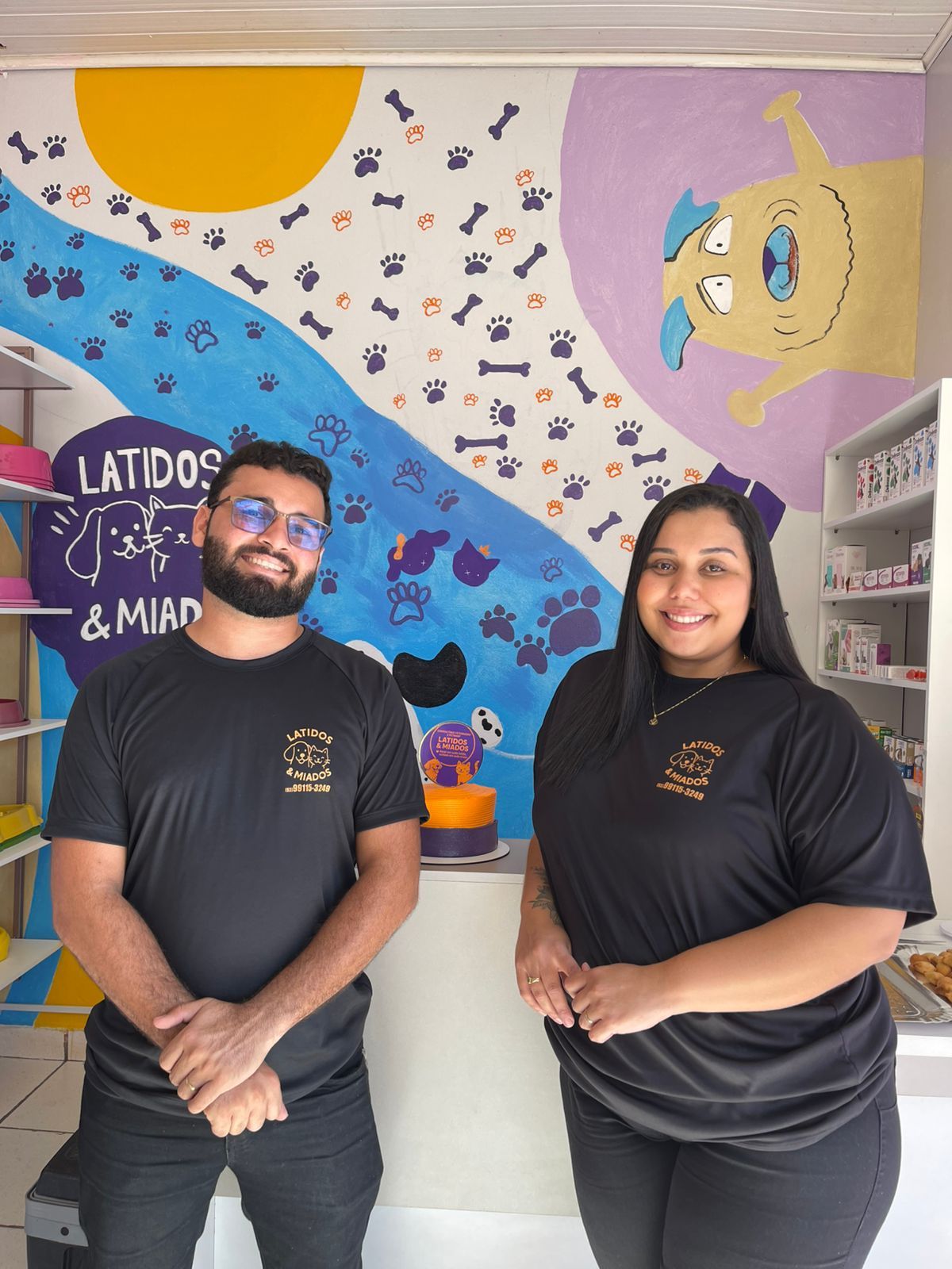 Equipe do Latidos & Miados em frente ao mural pintado à mão da loja